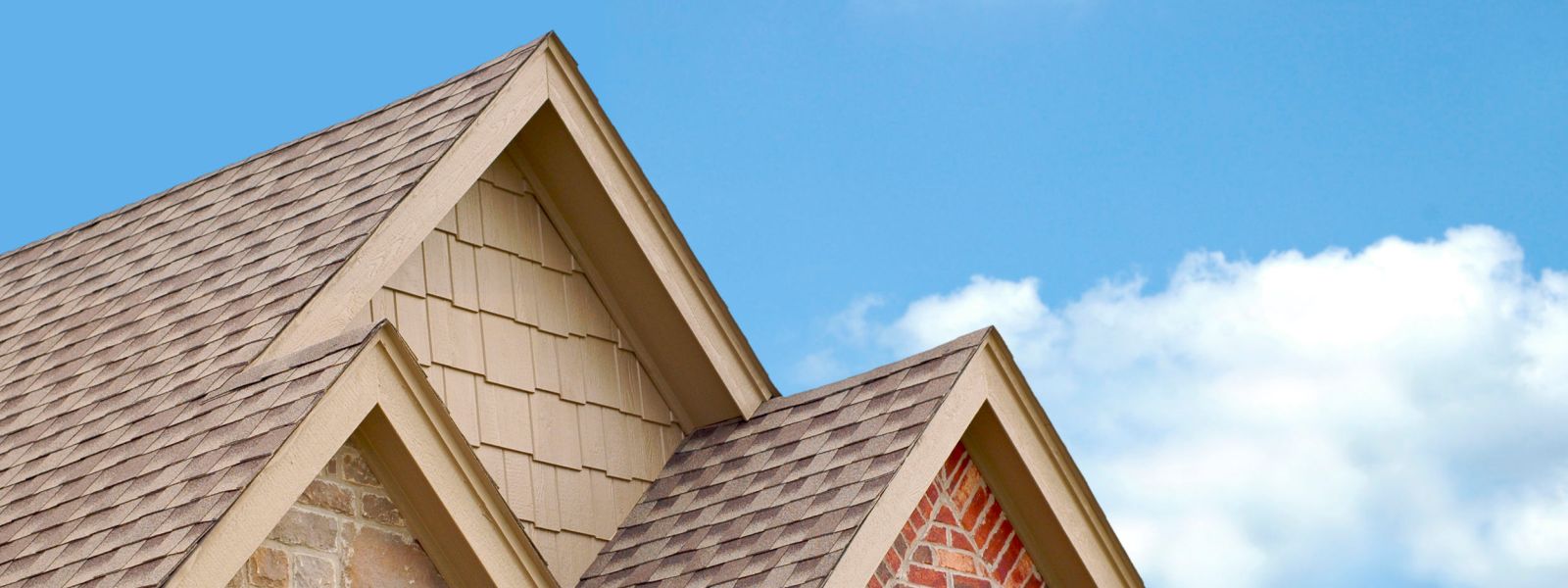 Roofing Exterior Remodeling service image of a roof with new asphalt shingles against a blue sky.